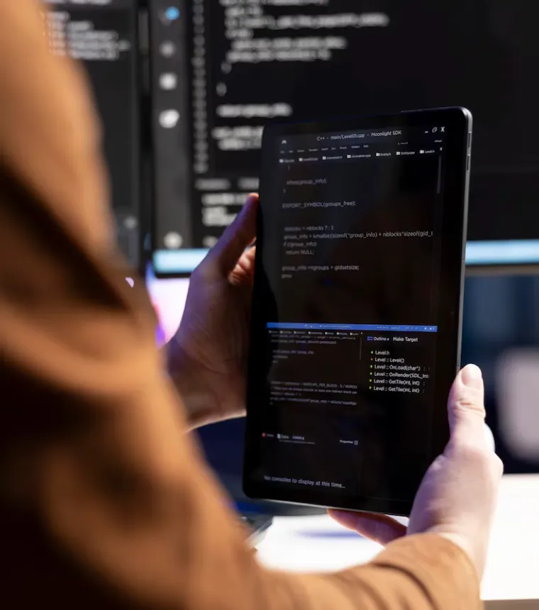 Tablet se zdrojovým kódem v rukou vývojáře
